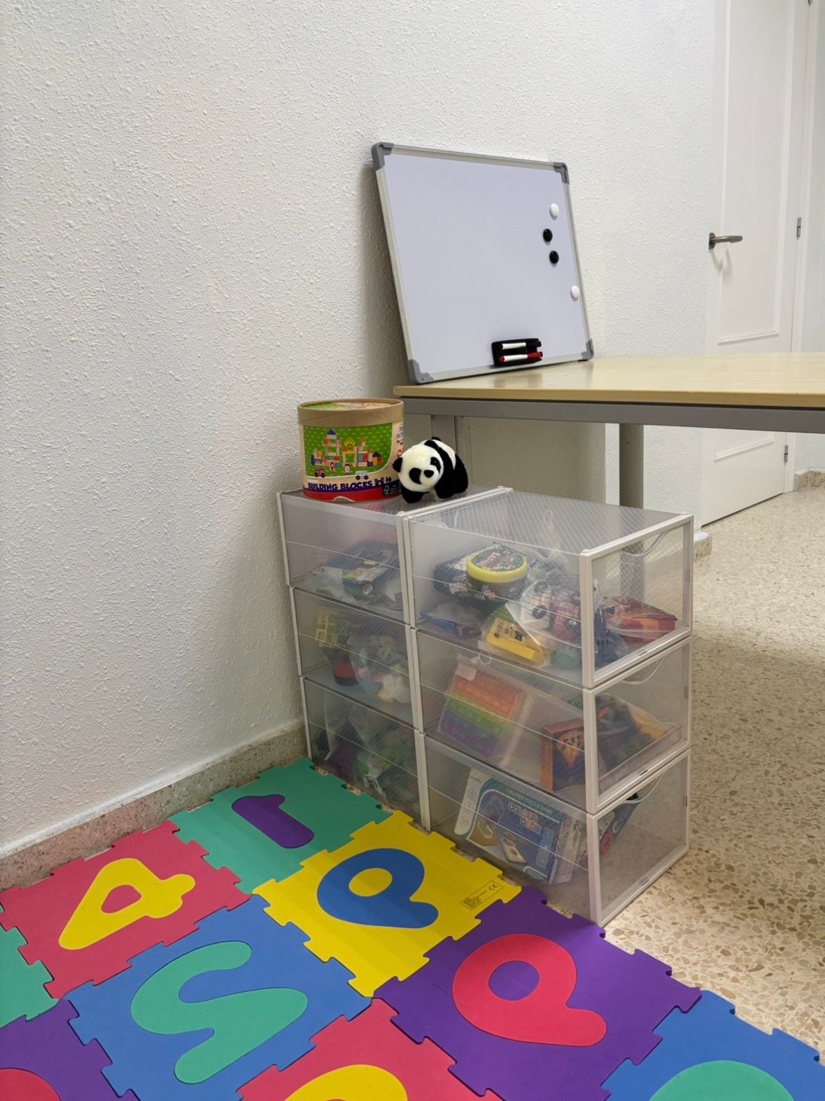 Espacio de trabajo infantil con pizarra y material terapéutico